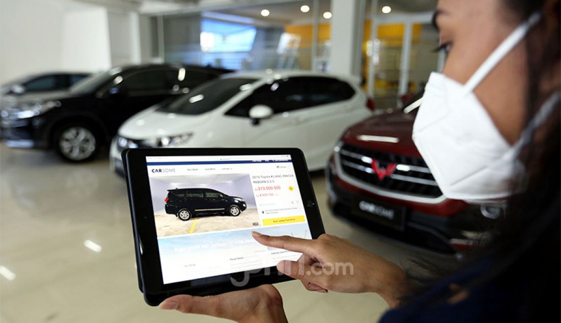 Pegawai Carsome Pondok Indah Experience Center, Jakarta, menunjukkan sejumlah mobil yang ditawarkan kepada calon pembeli. - JPNN.com