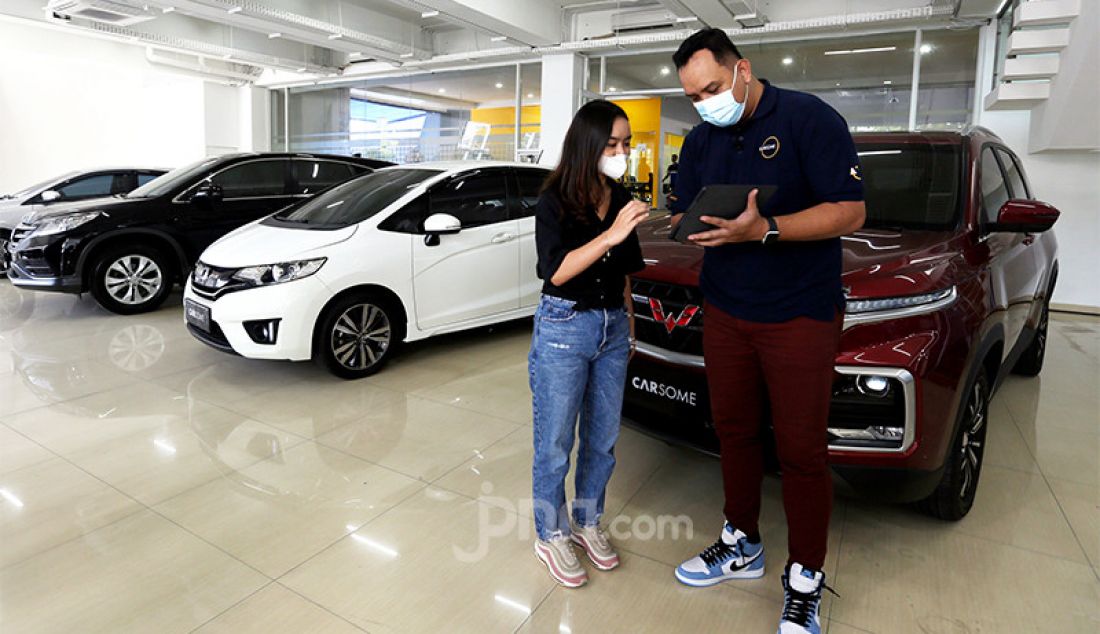 Country Head of Carsome Indonesia Delly Nugraha saat berbincang dengan calon pembeli di Carsome Pondok Indah Experience Center, Jakarta. - JPNN.com