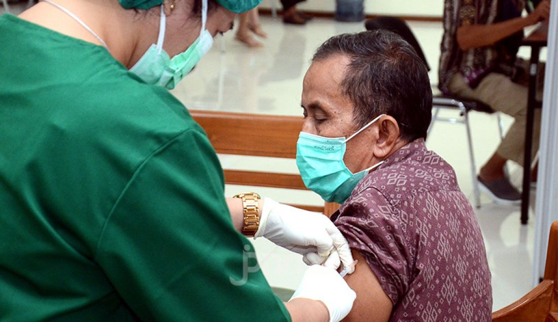 Petugas kesehatan menyuntikkan vaksin Covid-19 kepada lansia di Jakarta, Selasa (27/4). Pemerintah melalui Otoritas Jasa Keuangan (OJK) mengadakan vaksinasi Covid-19 bagi para lansia dalam rangka program Vaksinasi Industri Keuangan Non-Bank. - JPNN.com