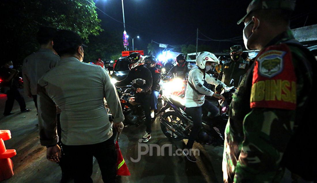 Petugas gabungan dari TNI, Polri, Satpol PP, dan Dishub Kabupaten Bekasi memeriksa para pengendara sepeda motor di titik penyekatan perbatasan Kabupaten Bekasi dan Kabupaten Karawang, Jawa Barat, Senin malam (10/5). Penyekatan itu merupakan tindak lanjut atas kebijakan pemerintah tentang larangan mudik yang berlaku 6-17 Mei 2021. - JPNN.com