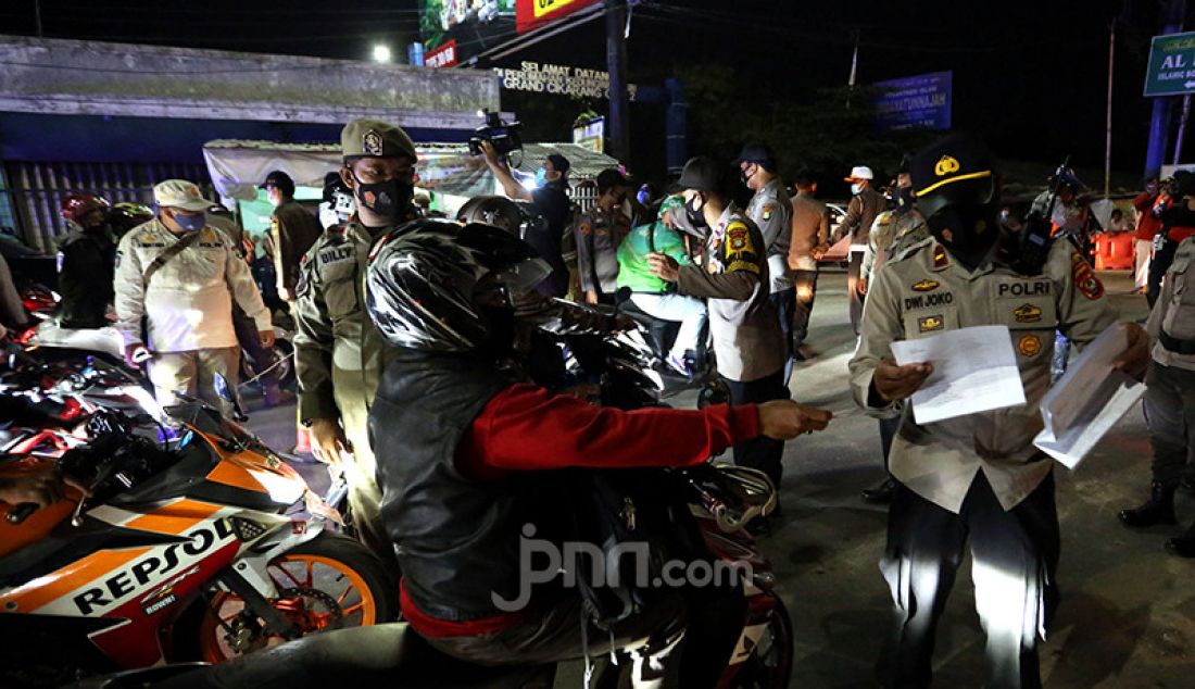 Petugas gabungan dari TNI, Polri, Satpol PP, dan Dishub Kabupaten Bekasi memeriksa para pengendara sepeda motor di titik penyekatan perbatasan Kabupaten Bekasi dan Kabupaten Karawang, Jawa Barat, Senin malam (10/5). Penyekatan itu merupakan tindak lanjut atas kebijakan pemerintah tentang larangan mudik yang berlaku 6-17 Mei 2021. - JPNN.com