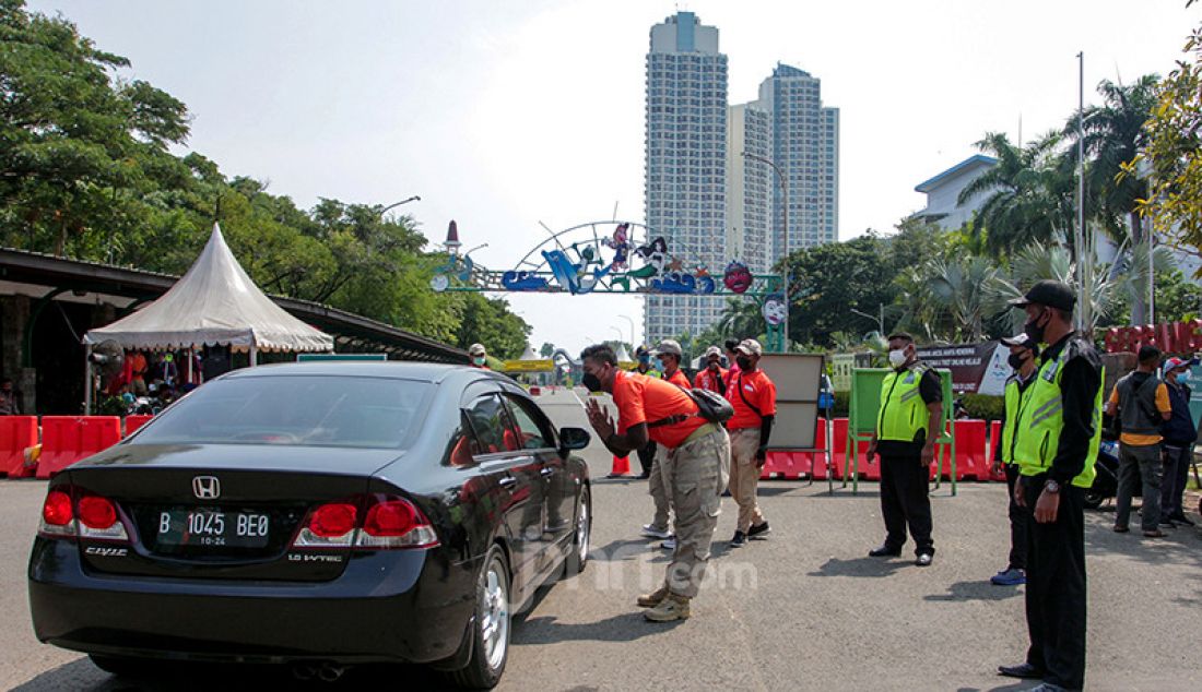 Petugas kepolisian memberhentikan kendaraan di pintu masuk Taman Impian Jaya Ancol, Jakarta Utara, Sabtu (15/5). Pengelola Ancol menutup seluruh area rekreasi dan wisatanya selama sehari guna penyemprotan disinfektan dan evaluasi penguatan protokol kesehatan. - JPNN.com