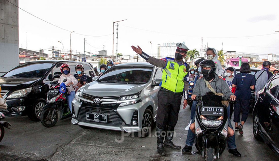 Petugas kepolisian memberhentikan kendaraan di pintu masuk Ancol Taman Impian, Jakarta, Sabtu (15/5). Pengelola Ancol Taman Impian menutup seluruh area rekreasi dan wisata selama satu hari pada Sabtu (15/5) untuk dilakukan penyemprotan disinfektan dan evaluasi penguatan protokol kesehatan. - JPNN.com