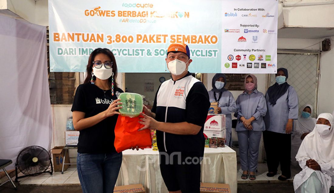VP Public Relations Blibli.com Yolanda Nainggolan (kiri) secara simbolis menyerahkan paket sembako dalam acara 
