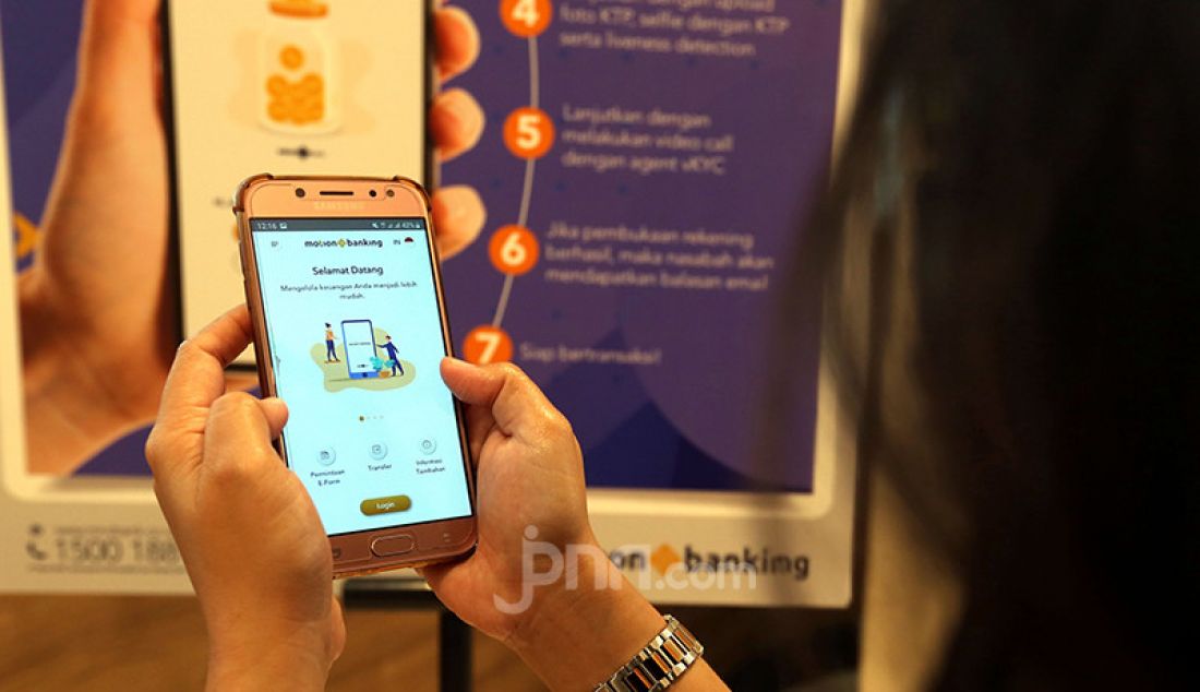 Seorang model menunjukkan aplikasi layanan perbankan digital MotionBanking saat pelucurannya di Jakarta, Kamis (3/6). Aplikasi tersebut merupakan layanan perbankan digital dan keuangan digital yang menjadi produk digital unggulan MNC Kapital. - JPNN.com