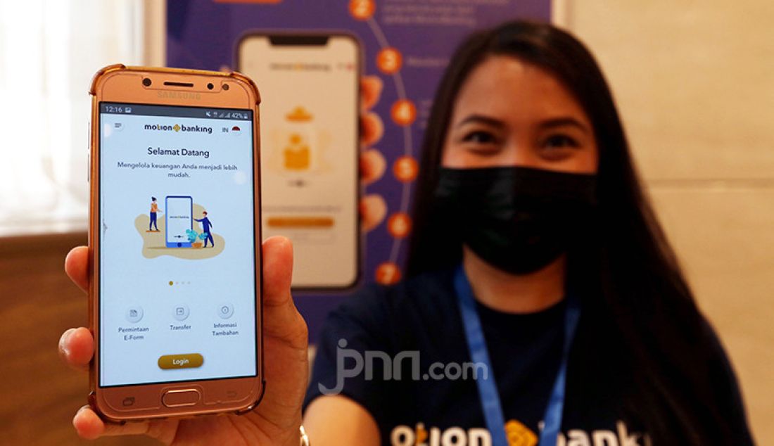 Seorang model menunjukkan aplikasi layanan perbankan digital MotionBanking saat pelucurannya di Jakarta, Kamis (3/6). Aplikasi tersebut merupakan layanan perbankan digital dan keuangan digital yang menjadi produk digital unggulan MNC Kapital. - JPNN.com