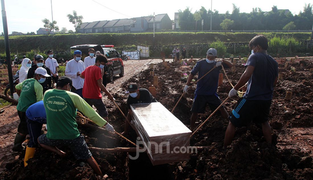 Petugas pemakaman di TPU Jombang, Tangerang Selatan (Tangsel), Banten, tengah memakamkan jenazah korban Covid-19, Senin (21/6). Angka kematian akibat Covid-19 di Tangsel pascalibur Lebaran meningkat rata-rata 20 persen. Dalam sehari terdapat 5-10 jenazah korban Covid-19 yang dimakamkan di TPU tersebut. - JPNN.com