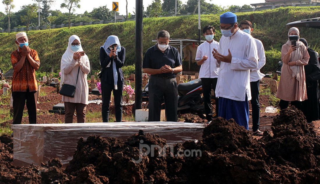 Keluarga korban Covid-19 berdoa pada proses pemakaman jenazah di TPU Jombang, Tangerang Selatan (Tangsel), Banten, Senin (21/6). Angka kematian akibat Covid-19 di Tangsel pascalibur Lebaran meningkat rata-rata 20 persen. Dalam sehari terdapat 5-10 jenazah korban Covid-19 yang dimakamkan di TPU tersebut. - JPNN.com