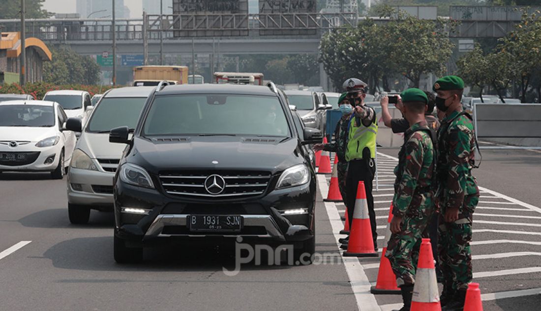 Petugas gabungan dari TNI dan Polri memeriksa setiap kendaraan yang melintas di Tol Dalam Jakarta Kota, Jakarta, Senin (5/7). Penyekatan ini dalam rangka Pemberlakuan Pembatasan Kegiatan Masyarakat (PPKM) Darurat yang berlangsung hingga 20 Juli 2021. - JPNN.com