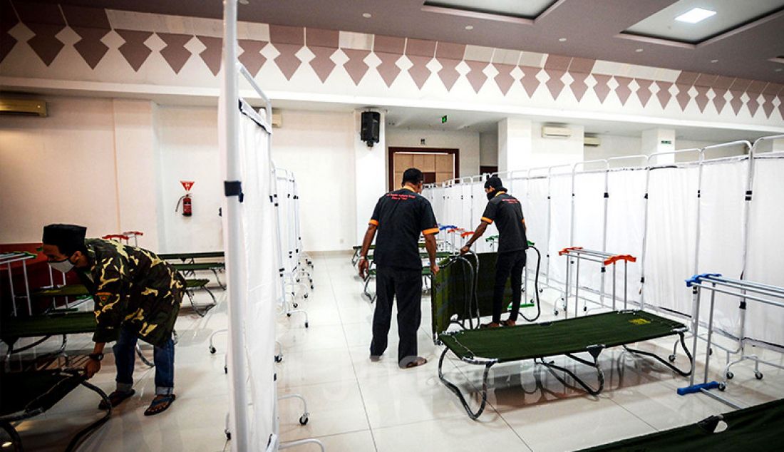 Petugas menyiapkan velbed untuk tempat tidur pasien Covid-19 di GOR Matraman, Jakarta, Jumat (16/7). GOR Matraman siap difungsikan menjadi tempat isolasi bagi pasien Covid-19 berstatus orang tanpa gejala (OTG) dan bergejala ringan. - JPNN.com