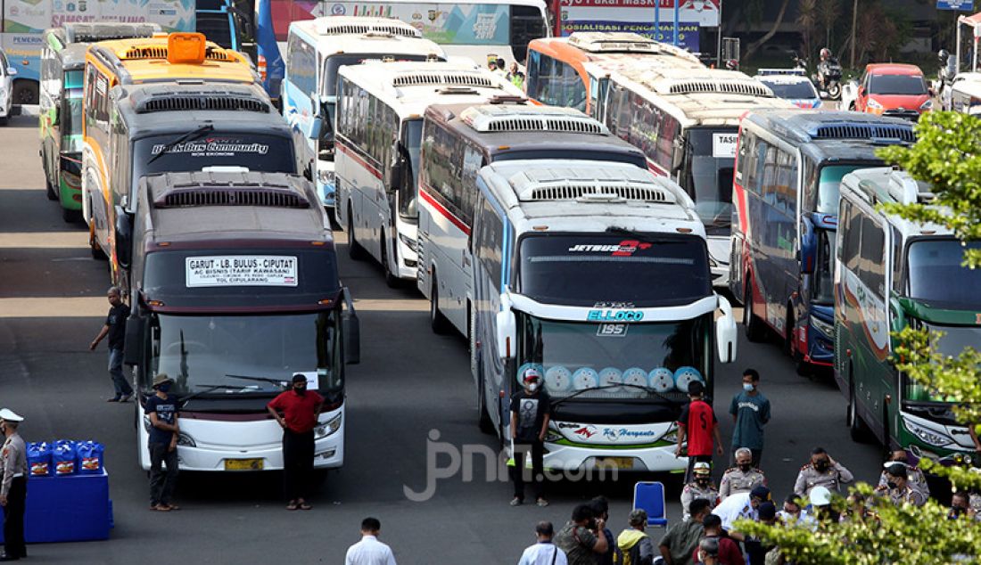 Puluhan bus yang melanggar Pemberlakuan Pembatasan Kegiatan Masyarakat (PPKM) Darurat terparkir di Mapolda Metro Jaya, Jakarta, Sabtu (17/7). Polisi menjaring 36 bus yang kedapatan melanggar ketentuan PPKM Darurat. - JPNN.com