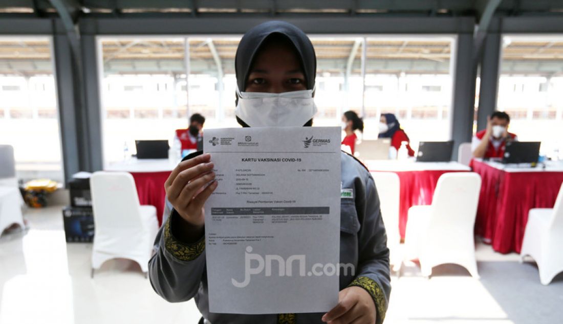 Calon penumpang menunjukkan surat kartu vaksin usai mengikuti vaksinasi vaksin COVID-19 di Stasiun KRL Jakarta Kota, Rabu (28/7). KAI Commuter menambah lokasi vaksinasi di Stasiun Duri, Angke dan Jakarta Kota bagi para penumpang dan warga sekitar stasiun yang dilaksanakan setiap jam 10.00 - 14.00 WIB. - JPNN.com