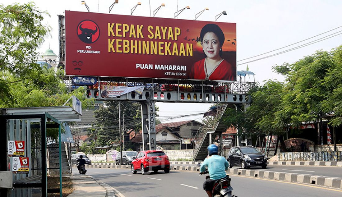 Para pengguna jalan di Jalan Raya Ciputat, Tangerang Selatan, Banten, melintas di bawah bawah baliho bergambar Ketua DPR Puan Maharani, Jumat (30/7). - JPNN.com