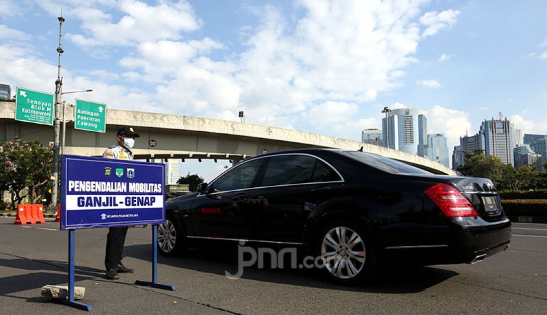 Aparat Polda Metro Jaya dibantu jajaran Dishub DKI Jakarta melarang pengendara mobil berpelat nomor ganjil memasuki Jalan Sudirman di kawasan Simpang Susun Semanggi, Jakarta, Kamis (12/8). Pemprov DKI Jakarta kembali menerapkan sistem ganjil genap di delapan ruas jalan di Jakarta pada pukul 06.00-20.00 WIB meski masih dalam masa Pemberlakuan Pembatasan Kegiatan Masyarakat (PPKM). - JPNN.com