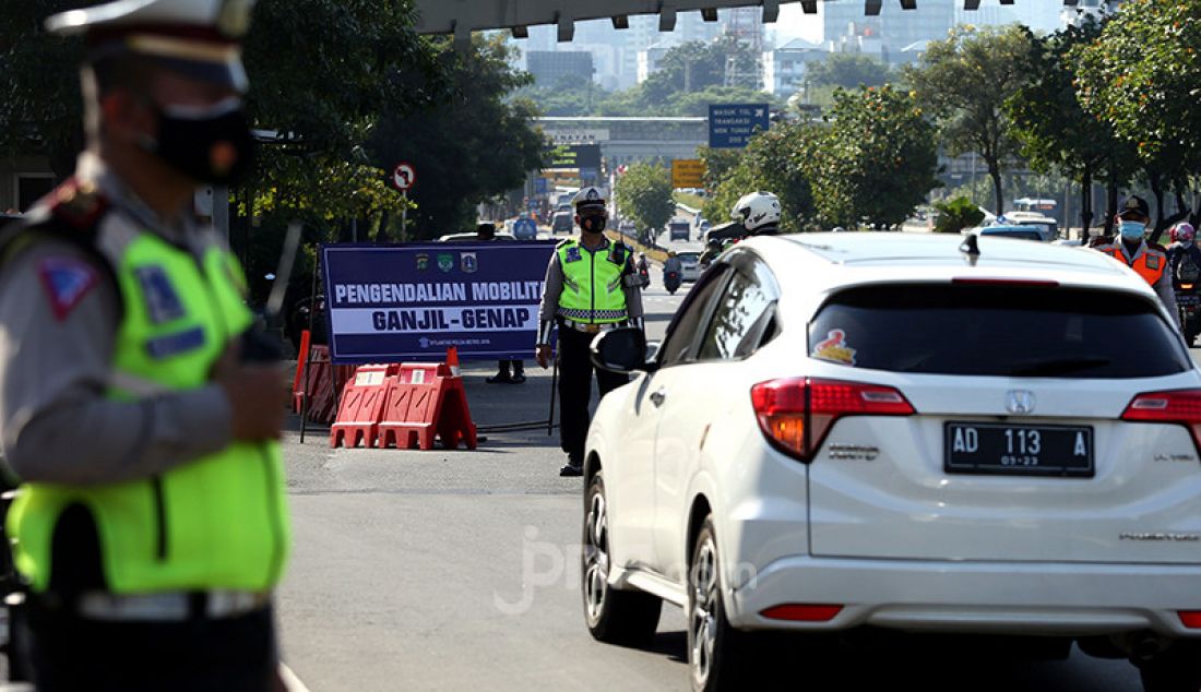 Aparat Polda Metro Jaya dibantu jajaran Dishub DKI Jakarta melarang pengendara mobil berpelat nomor ganjil memasuki Jalan Sudirman di kawasan Simpang Susun Semanggi, Jakarta, Kamis (12/8). Pemprov DKI Jakarta kembali menerapkan sistem ganjil genap di delapan ruas jalan di Jakarta pada pukul 06.00-20.00 WIB meski masih dalam masa Pemberlakuan Pembatasan Kegiatan Masyarakat (PPKM). - JPNN.com