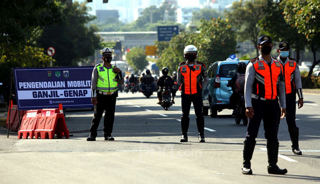 Aparat Polda Metro Jaya dibantu jajaran Dishub DKI Jakarta melarang pengendara mobil berpelat nomor ganjil memasuki Jalan Sudirman di kawasan Simpang Susun Semanggi, Jakarta, Kamis (12/8). Pemprov DKI Jakarta kembali menerapkan sistem ganjil genap di delapan ruas jalan di Jakarta pada pukul 06.00-20.00 WIB meski masih dalam masa Pemberlakuan Pembatasan Kegiatan Masyarakat (PPKM). - JPNN.com