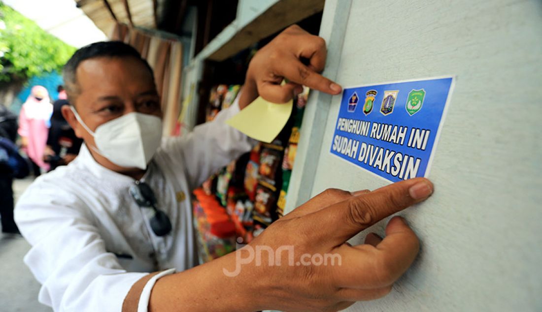 Tim Satgas Covid-19 DKI Jakarta menempelkan stiker di rumah yang penguninya sudah divaksinasi di kawasan RW 05 Sunter Agung, Jakarta Utara, Jumat (13/8). - JPNN.com