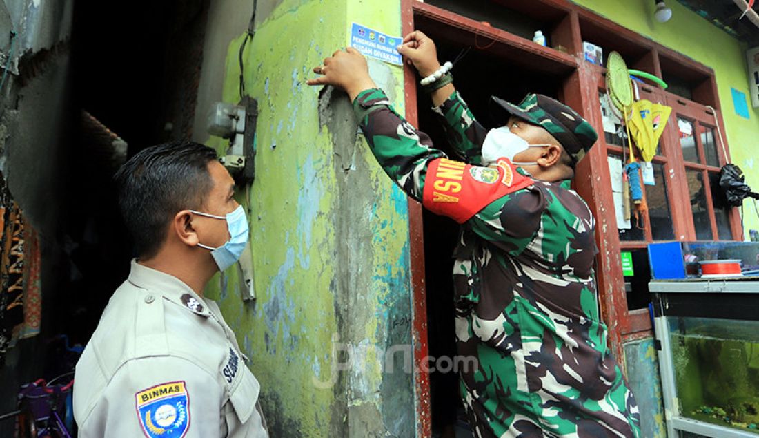 Tim Satgas Covid-19 DKI Jakarta menempelkan stiker di rumah yang penguninya sudah divaksinasi di kawasan RW 05 Sunter Agung, Jakarta Utara, Jumat (13/8). - JPNN.com