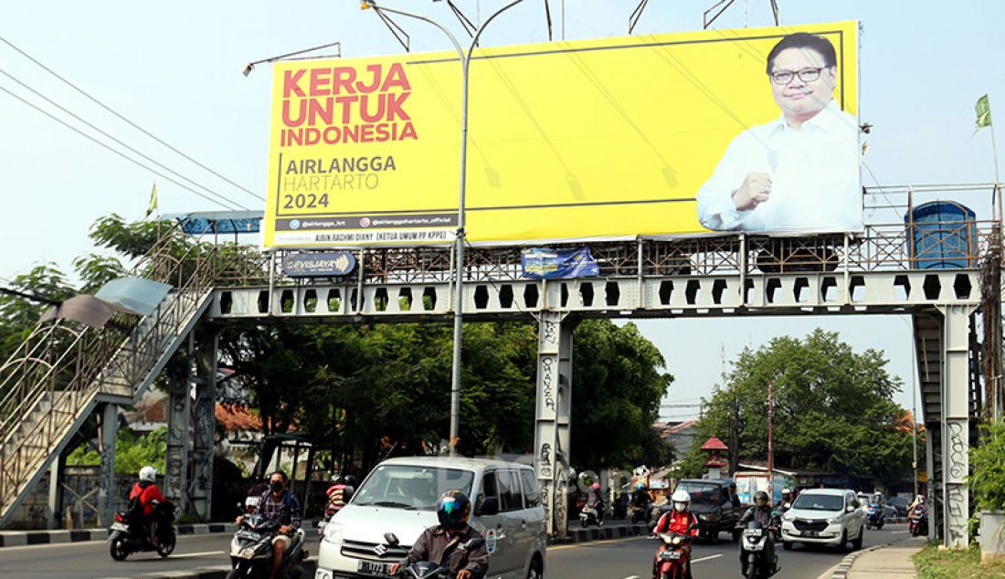 Sejumlah pengguna jalan melintas di bawah Baliho Airlangga Hartarto di Jalan Raya Ciputat, Tangerang Selatan, Banten, Rabu (18/8). - JPNN.com