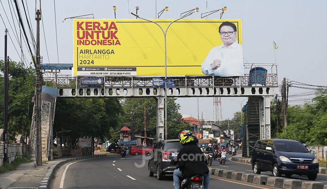 Sejumlah pengguna jalan melintas di bawah Baliho Airlangga Hartarto di Jalan Raya Ciputat, Tangerang Selatan, Banten, Rabu (18/8). - JPNN.com