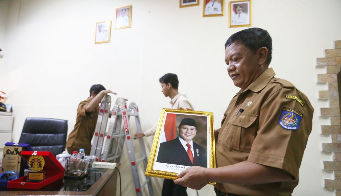 Kepala Sekolah SMPN 2 Depok Sumarno memegang foto Presiden Prabowo Subianto untuk menggantikan foto Presiden ketujuh RI Joko Widodo di ruang kepala sekolah di SMPN 2 Depok, Jawa Barat, Senin (21/10). Prabowo Subianto dan Gibran Rakabuming Raka dilantik sebagai Presiden dan Wakil Presiden Republik Indonesia masa bakti 2024-2029. - JPNN.com