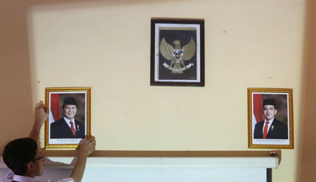 Murid kelas IX memasang foto Presiden Prabowo Subianto untuk menggantikan foto Presiden ketujuh RI Joko Widodo di kelas SMPN 2 Depok, Jawa Barat, Senin (21/10). Prabowo Subianto dan Gibran Rakabuming Raka dilantik sebagai Presiden dan Wakil Presiden Republik Indonesia masa bakti 2024-2029. - JPNN.com