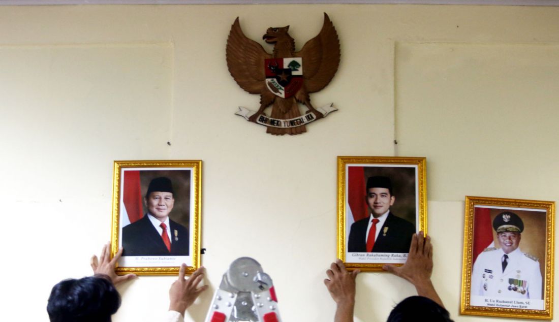 Petugas memasang foto Presiden Prabowo Subianto untuk menggantikan foto Presiden ketujuh RI Joko Widodo di ruang kepala sekolah di SMPN 2 Depok, Jawa Barat, Senin (21/10). Prabowo Subianto dan Gibran Rakabuming Raka dilantik sebagai Presiden dan Wakil Presiden Republik Indonesia masa bakti 2024-2029. - JPNN.com