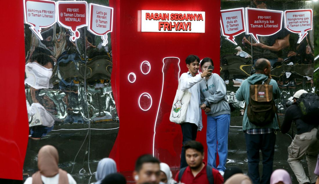 Warga saat selfie di instalasi “Guerrilla Interactive” di Stasiun MRT, Kawasan Dukuh Atas, Jakarta, Jumat (25/10). COCA-COLA meluncurkan kampanye “Rasain Keseruan Fri-yay” dengan menghadirkan 