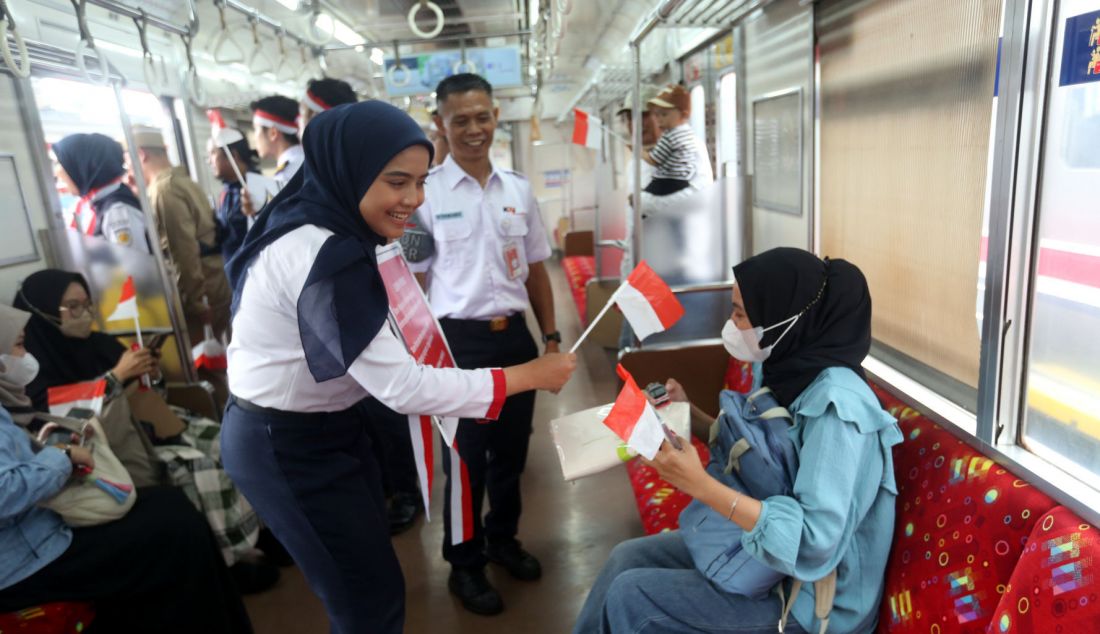 Pegawai KAI Commuter saat membagikan sovenir pada peringatan Hari Sumpah pemuda 28 Oktober di Stasiun Bogor, Jawa Barat, Senin (28/10). KAI Commuter yang merupakan operator KRL Commuterline merayakan hari Sumpah Pemuda bersama penumpang di Stasiun Bogor dengan melakukan ikrar Sumpah Pemuda dan membagikan bendera kecil suvenir dan coklat kepada para penumpang. - JPNN.com