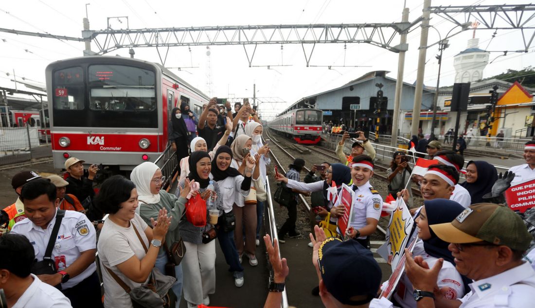 Pegawai KAI Commuter saat membagikan sovenir pada peringatan Hari Sumpah pemuda 28 Oktober di Stasiun Bogor, Jawa Barat, Senin (28/10). KAI Commuter yang merupakan operator KRL Commuterline merayakan hari Sumpah Pemuda bersama penumpang di Stasiun Bogor dengan melakukan ikrar Sumpah Pemuda dan membagikan bendera kecil suvenir dan coklat kepada para penumpang. - JPNN.com