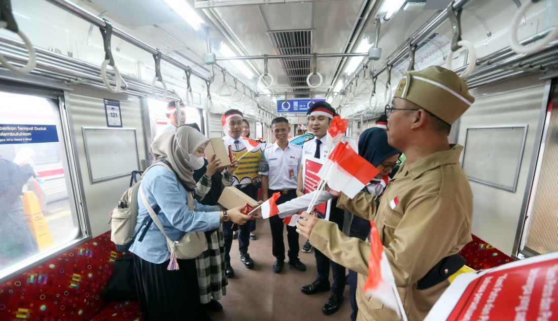 Pegawai KAI Commuter saat membagikan sovenir pada peringatan Hari Sumpah pemuda 28 Oktober di Stasiun Bogor, Jawa Barat, Senin (28/10). KAI Commuter yang merupakan operator KRL Commuterline merayakan hari Sumpah Pemuda bersama penumpang di Stasiun Bogor dengan melakukan ikrar Sumpah Pemuda dan membagikan bendera kecil suvenir dan coklat kepada para penumpang. - JPNN.com