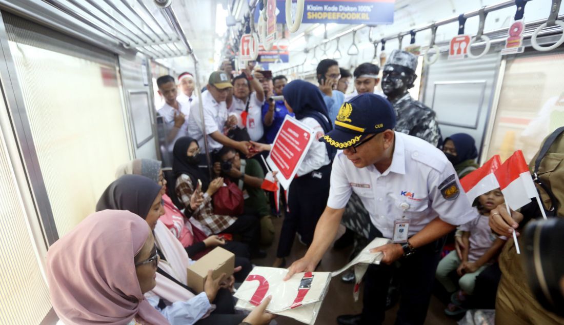 VP Corporate Secretary KAI Commuter Joni Martinus membagikan sovenir pada peringatan Hari Sumpah pemuda 28 Oktober di Stasiun Bogor, Jawa Barat, Senin (28/10). KAI Commuter yang merupakan operator KRL Commuterline merayakan hari Sumpah Pemuda bersama penumpang di Stasiun Bogor dengan melakukan ikrar Sumpah Pemuda dan membagikan bendera kecil suvenir dan coklat kepada para penumpang. - JPNN.com