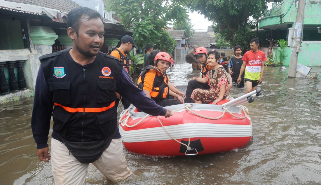 Tim SAR Badan Penanggulangan Bencana Daerah (BPBD) Tangsel mengevakuasi warga lansia sakit saat banjir menggenangi Perumahan Taman Mangu, Tangerang Selatan, Banten, Selasa (12/11). Lebih dari 320 KK menjadi korban. - JPNN.com