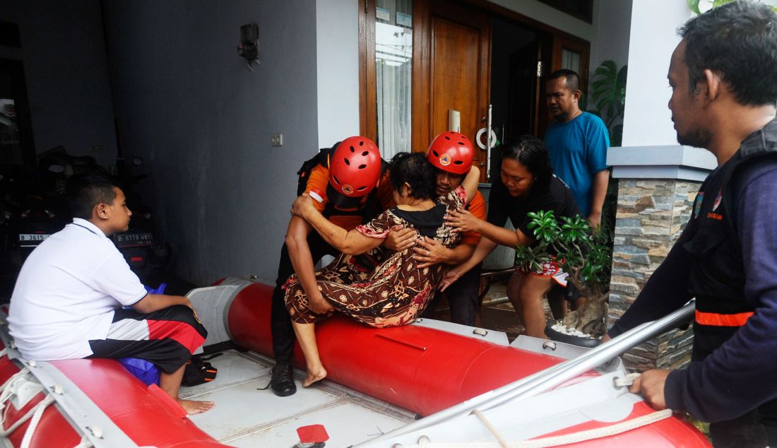 Tim SAR Badan Penanggulangan Bencana Daerah (BPBD) Tangsel mengevakuasi warga lansia sakit saat banjir menggenangi Perumahan Taman Mangu, Tangerang Selatan, Banten, Selasa (12/11). Lebih dari 320 KK menjadi korban. - JPNN.com