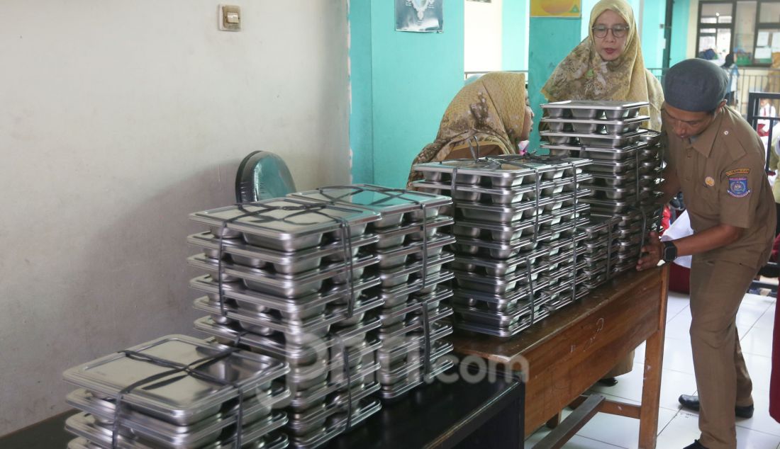 Guru merapikan tempat makan bergizi gratis (MBM) di SDN Lengkong Wetan 01, Tangerang Selatan, Banten, Senin (6/1). Hari ini program Makan Bergizi Gratis (MBG) yang menjadi program andalan Presiden Prabowo Subianto dimulai perdana pada di 26 provinsi di Indonesia. - JPNN.com