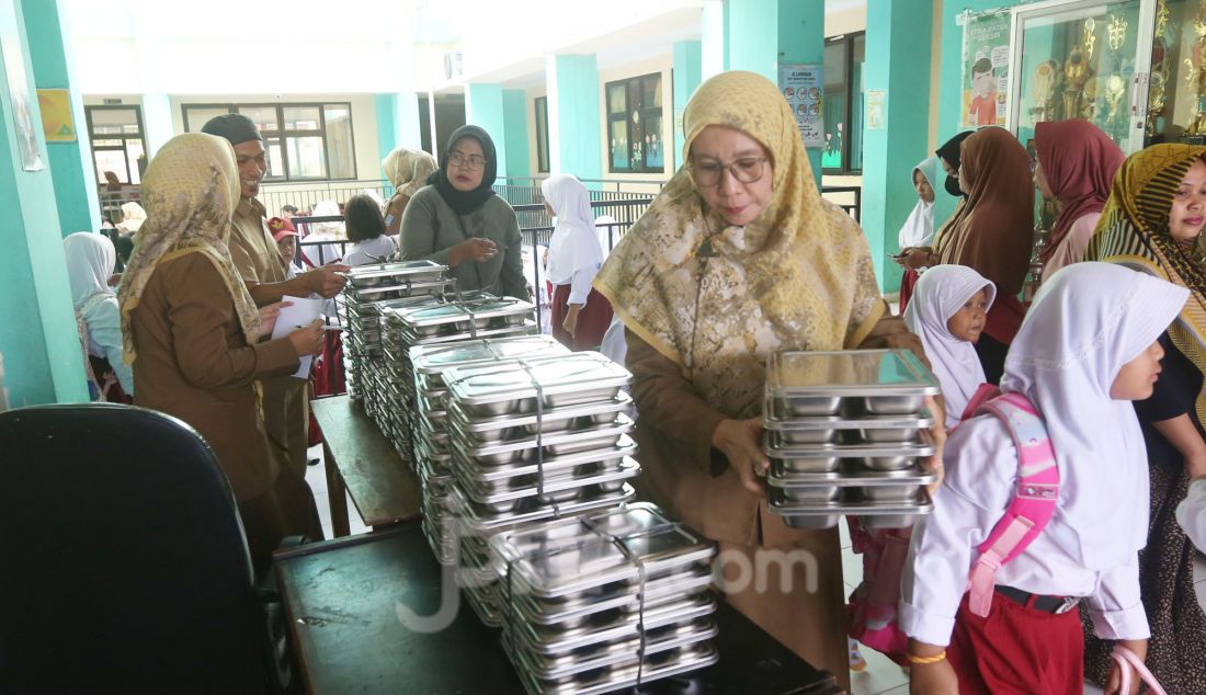 Guru merapikan tempat makan bergizi gratis (MBM) di SDN Lengkong Wetan 01, Tangerang Selatan, Banten, Senin (6/1). Hari ini program Makan Bergizi Gratis (MBG) yang menjadi program andalan Presiden Prabowo Subianto dimulai perdana pada di 26 provinsi di Indonesia. - JPNN.com