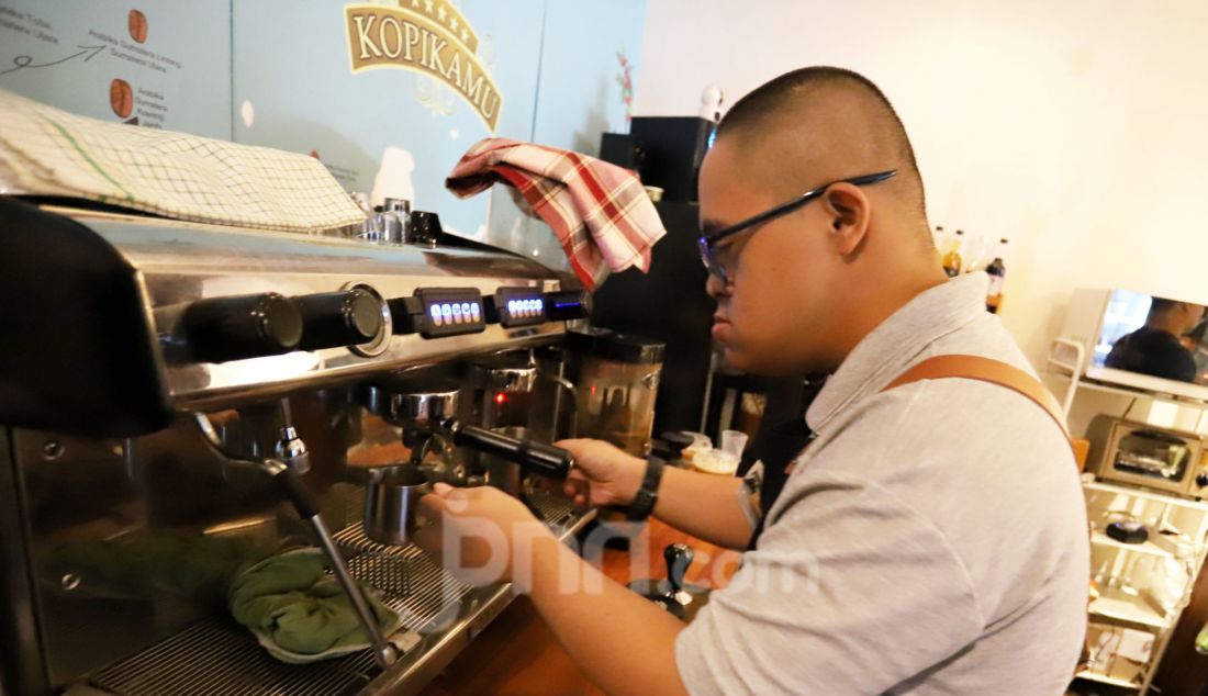 Seorang barista penyandang disabilitas down syndrom membuat kopi di Kopi Kamu, Jakarta Selatan, Kamis (9/1). Persatuan Orang Tua Anak Down Syndrome (POTADS) bekerja sama dengan kedai kopi memberdayakan tujuh penyandang disabilitas dengan keahlian barista sebagai upaya menciptakan lapangan kerja yang inklusif, khususnya bagi penyandang disabilitas. - JPNN.com