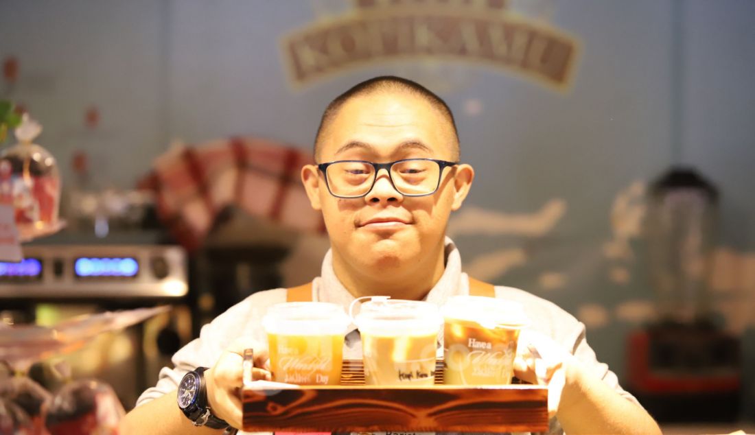 Seorang barista penyandang disabilitas down syndrom membuat kopi di Kopi Kamu, Jakarta Selatan, Kamis (9/1). Persatuan Orang Tua Anak Down Syndrome (POTADS) bekerja sama dengan kedai kopi memberdayakan tujuh penyandang disabilitas dengan keahlian barista sebagai upaya menciptakan lapangan kerja yang inklusif, khususnya bagi penyandang disabilitas. - JPNN.com