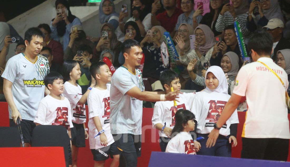 Pebulu tangkis ganda putra Indonesia Hendra Setiawan dan Mohammad Ahsan saat membawa putra dan putrinya disela bertanding melawan Pebulu tangkis ganda putra Malaysia Junaidi Arif dan Roy King Yap pada babak 16 besar Daihatsu Indonesia Masters 2025 di Istora Senayan, Jakarta, Kamis (23/1). Hendra/Ahsan gagal melaju ke perempat final usai kalah dengan skor 13-21 dan 14-21. - JPNN.com