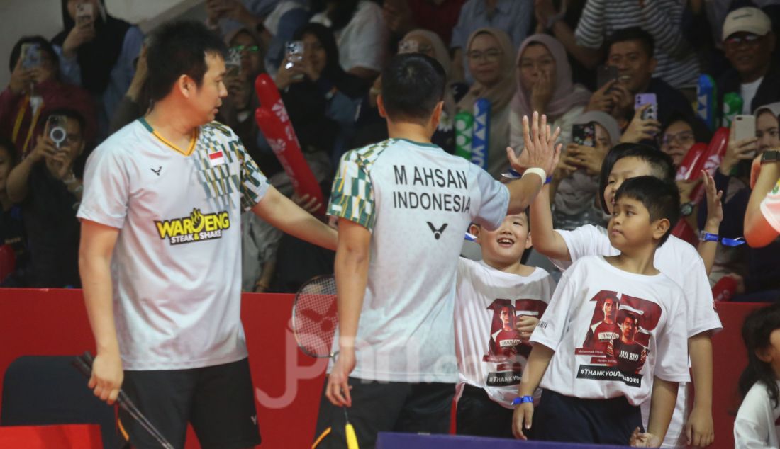 Pebulu tangkis ganda putra Indonesia Hendra Setiawan dan Mohammad Ahsan saat membawa putra dan putrinya disela bertanding melawan Pebulu tangkis ganda putra Malaysia Junaidi Arif dan Roy King Yap pada babak 16 besar Daihatsu Indonesia Masters 2025 di Istora Senayan, Jakarta, Kamis (23/1). Hendra/Ahsan gagal melaju ke perempat final usai kalah dengan skor 13-21 dan 14-21. - JPNN.com