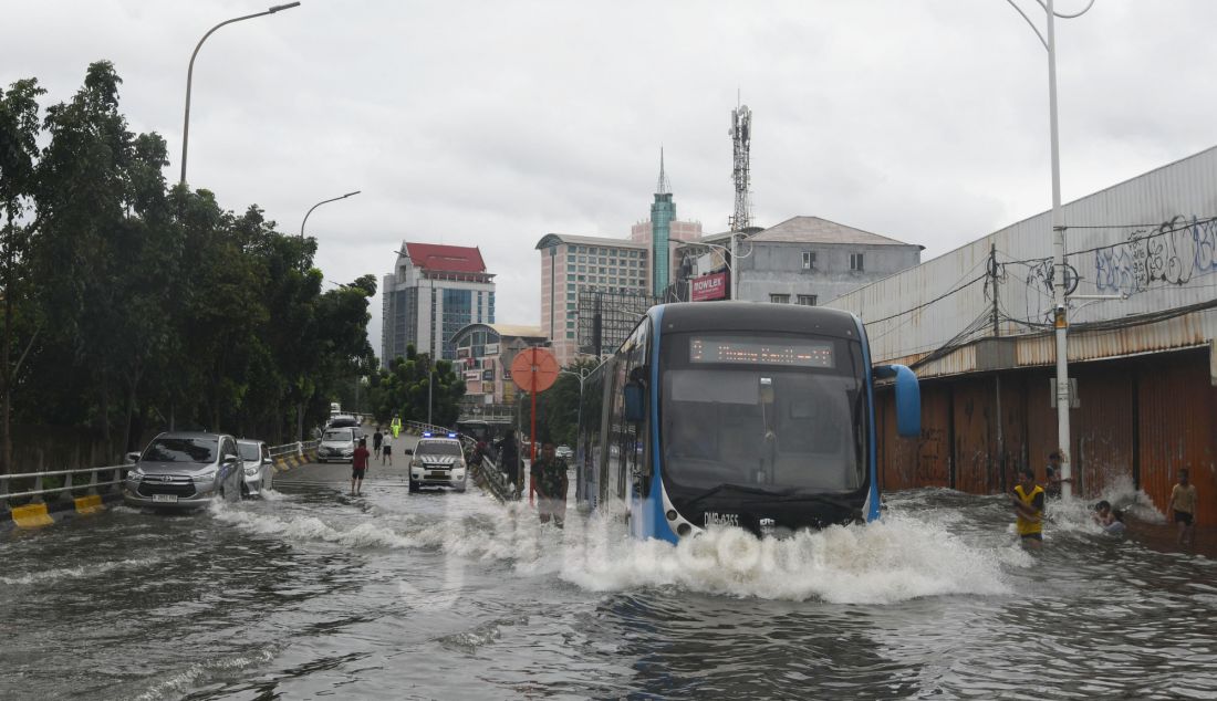 Bus TransJakarta melewati banjir pada ruas jalan Satrio, Grogol, jakarta Barat, Rabu (29/1). Hujan lebat yang melanda DKI Jakarta dan sekitarnya menyebabkan genangan di beberapa wilayah. Hingga siang ini, tercatat masih ada 34 RT dan 19 ruas jalan di Jakarta yang tergenang banjir. - JPNN.com