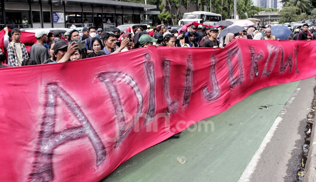 Massa dari Aliansi Rakyat Menggugat (ARM) berunjuk rasa dengan membentangkan spanduk bertuliskan Adili Jokowi dan kroninya di Mapolda Metro Jaya, Jakarta, Jumat (7/2). Melalui aksi unjuk rasa ini, massa ARM menuntut aparat penegak hukum, termasuk kepolisian, untuk segera menindaklanjuti berbagai laporan terkait kasus dugaan korupsi yang melibatkan Presiden ketujuh RI, Joko Widodo atau Jokowi beserta keluarganya. - JPNN.com