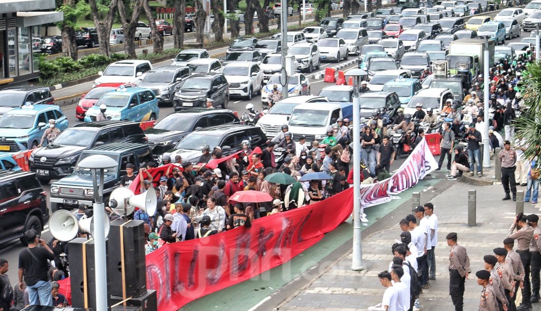 Massa dari Aliansi Rakyat Menggugat (ARM) berunjuk rasa dengan membentangkan spanduk bertuliskan Adili Jokowi dan kroninya di Mapolda Metro Jaya, Jakarta, Jumat (7/2). Melalui aksi unjuk rasa ini, massa ARM menuntut aparat penegak hukum, termasuk kepolisian, untuk segera menindaklanjuti berbagai laporan terkait kasus dugaan korupsi yang melibatkan Presiden ketujuh RI, Joko Widodo atau Jokowi beserta keluarganya. - JPNN.com