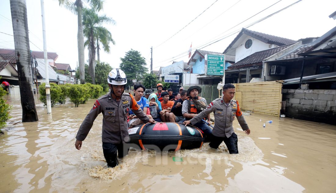 Tim gabungan BPBD mengevakuasi korban banjir di perumahan Vila Nusa Indah 3, Gunung Putri, Kabupaten Bogor, Jawa Barat, Selasa (4/3). Banjir yang terjadi di kawasan perbatasan Bogor dan Bekasi akibat luapan kali Cikeas dan Cileungsi menyebabkan ketinggian air hingga 4 meter di rumah warga. - JPNN.com