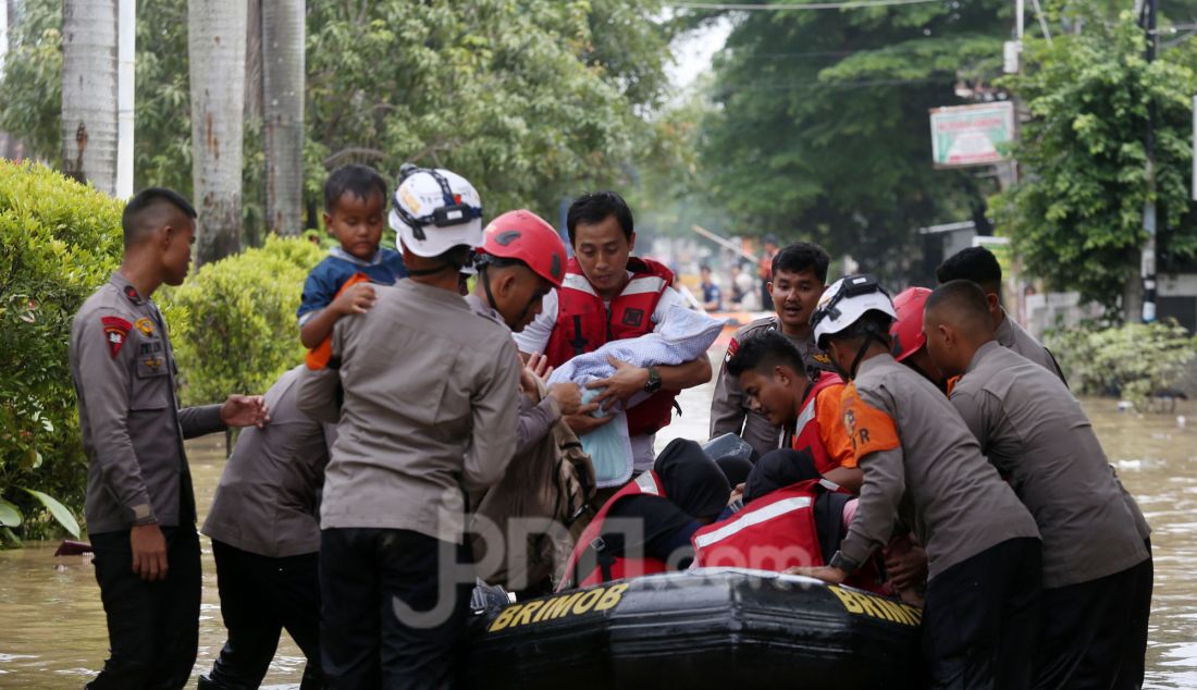 Tim gabungan BPBD mengevakuasi korban banjir di perumahan Vila Nusa Indah 3, Gunung Putri, Kabupaten Bogor, Jawa Barat, Selasa (4/3). Banjir yang terjadi di kawasan perbatasan Bogor dan Bekasi akibat luapan kali Cikeas dan Cileungsi menyebabkan ketinggian air hingga 4 meter di rumah warga. - JPNN.com