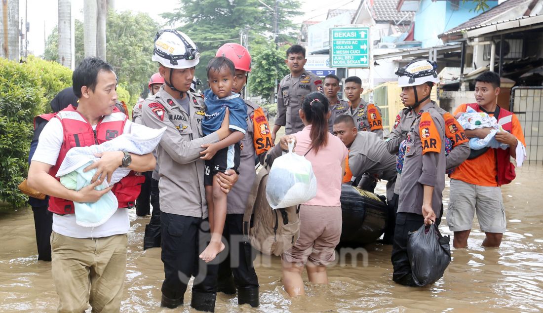 Tim gabungan BPBD mengevakuasi korban banjir di perumahan Vila Nusa Indah 3, Gunung Putri, Kabupaten Bogor, Jawa Barat, Selasa (4/3). Banjir yang terjadi di kawasan perbatasan Bogor dan Bekasi akibat luapan kali Cikeas dan Cileungsi menyebabkan ketinggian air hingga 4 meter di rumah warga. - JPNN.com