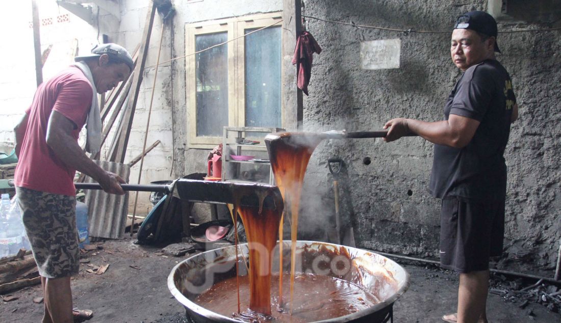 Pekerja mengaduk adonan dodol Betawi di pusat pembuatan dodol, kawasan Cilenggang, Serpong, Tangerang Selatan, Banten, Rabu (19/3). Menjelang Idulfitri permintaan dodol Betawi meningkat, dijual seharga Rp 62 ribu per kilogram. - JPNN.com