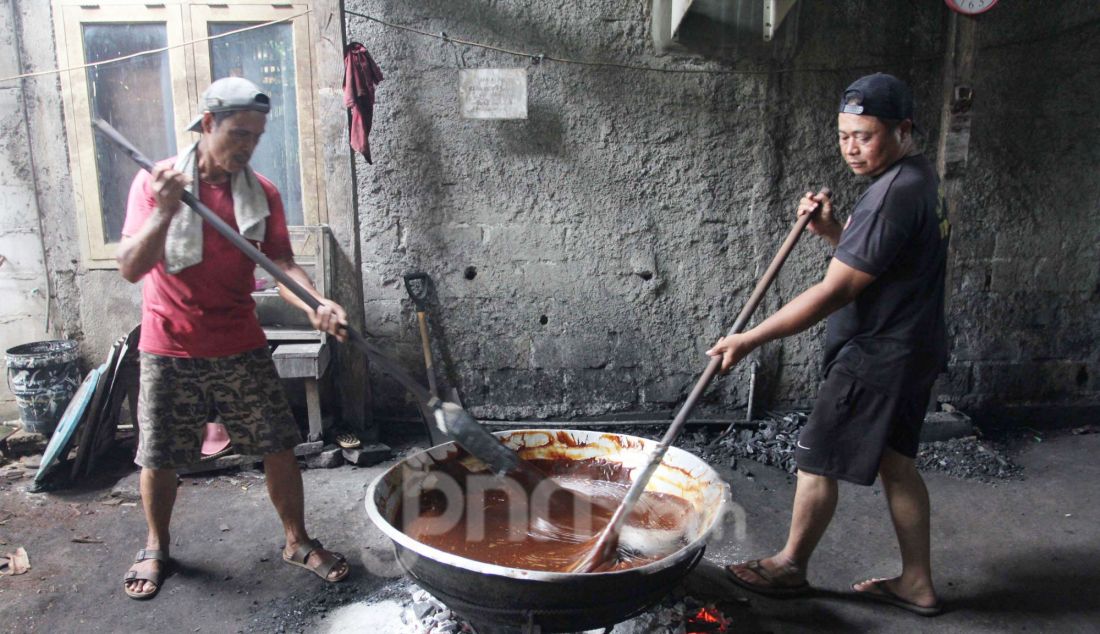 Pekerja mengaduk adonan dodol Betawi di pusat pembuatan dodol, kawasan Cilenggang, Serpong, Tangerang Selatan, Banten, Rabu (19/3). Menjelang Idulfitri permintaan dodol Betawi meningkat, dijual seharga Rp 62 ribu per kilogram. - JPNN.com