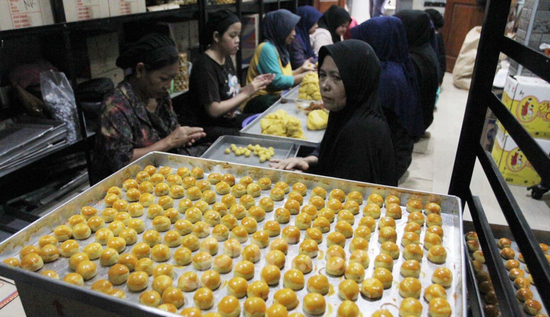 Pekerja memproduksi kue kering di Botisha Cookes Kampung Nastar, Larangan, Tangerang, Banten, Kamis (20/3). Berbagai jenis kue kering skala rumahan seperti nastar, putri salju, mete coklat dan kastengel untuk kebutuhan Lebaran tersebut dijual dengan harga Rp 60.000 hingga Rp 90.000 per toples tergantung jenis kue. - JPNN.com