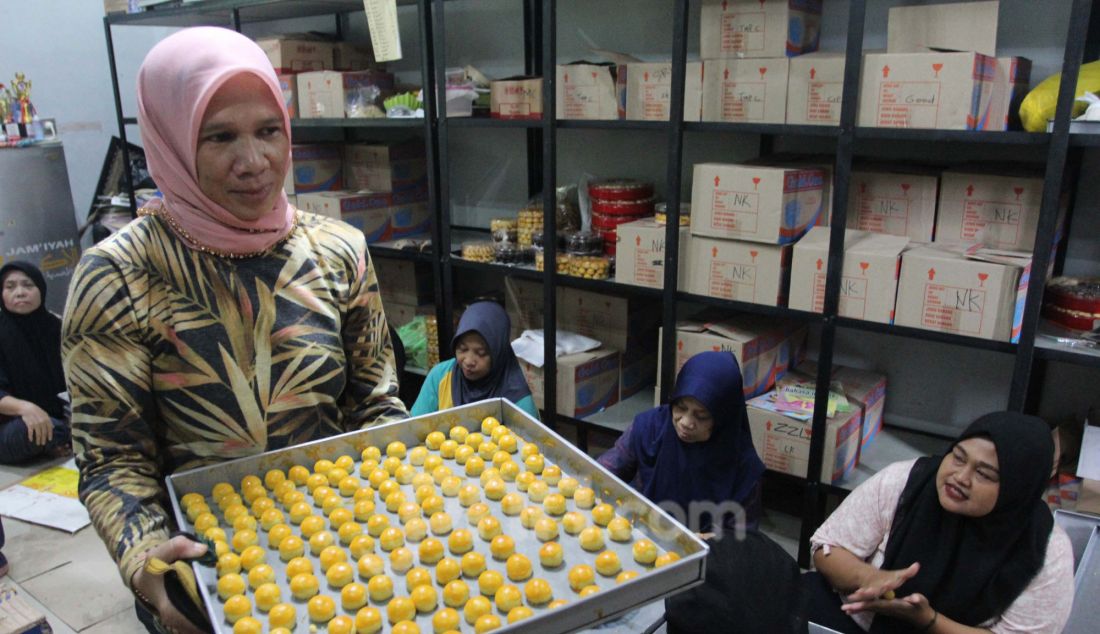 Pekerja memproduksi kue kering di Botisha Cookes Kampung Nastar, Larangan, Tangerang, Banten, Kamis (20/3). Berbagai jenis kue kering skala rumahan seperti nastar, putri salju, mete coklat dan kastengel untuk kebutuhan Lebaran tersebut dijual dengan harga Rp 60.000 hingga Rp 90.000 per toples tergantung jenis kue. - JPNN.com